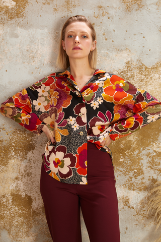 La chemise Jenna, inspirée des motifs des années 70, est confectionnée avec minutie à Montréal, ajoutant ainsi une touche d'originalité marquante à votre tenue.