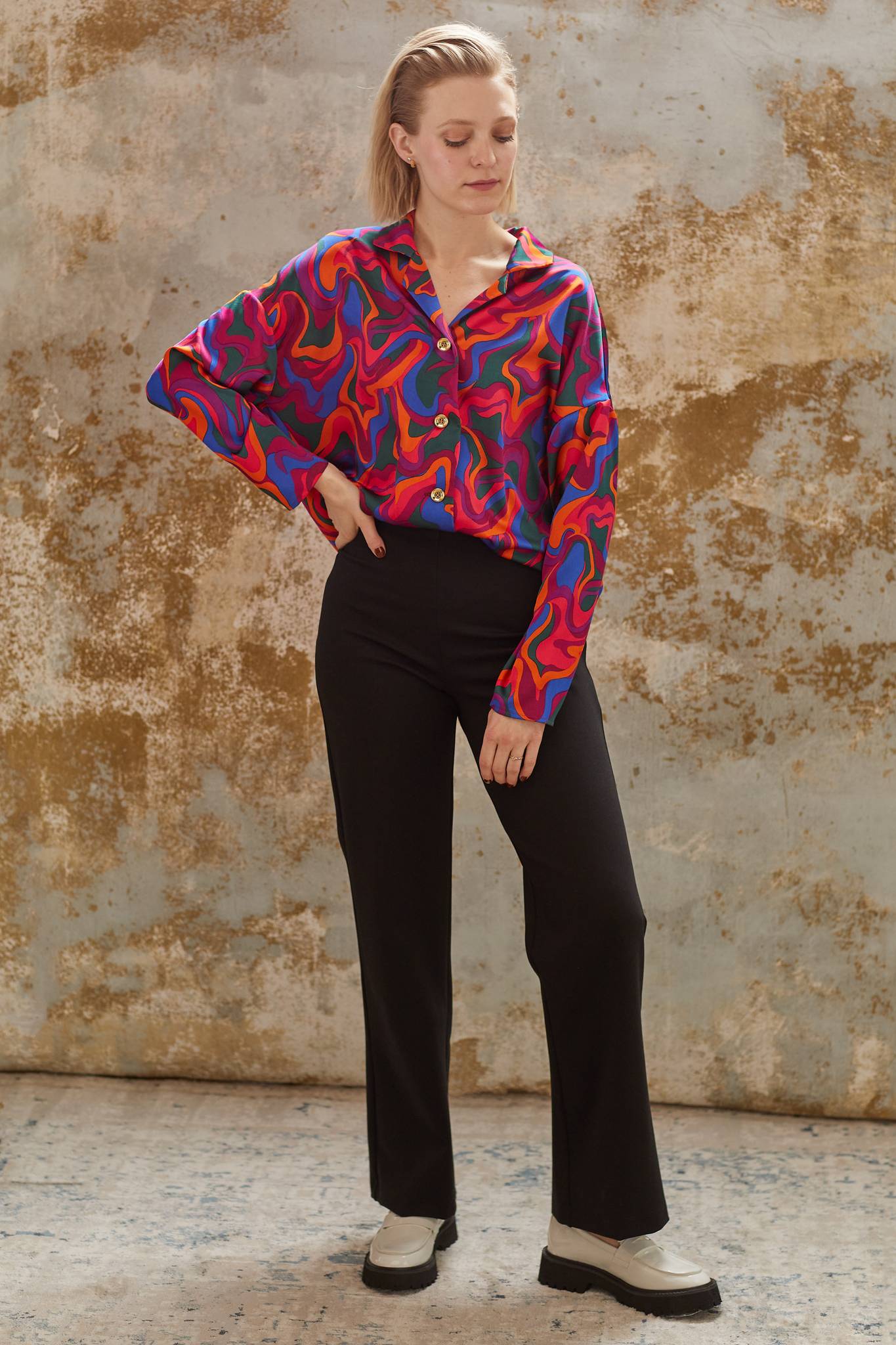 La chemise Jenna, inspirée des motifs des années 70, est confectionnée avec minutie à Montréal, ajoutant ainsi une touche d'originalité marquante à votre tenue.